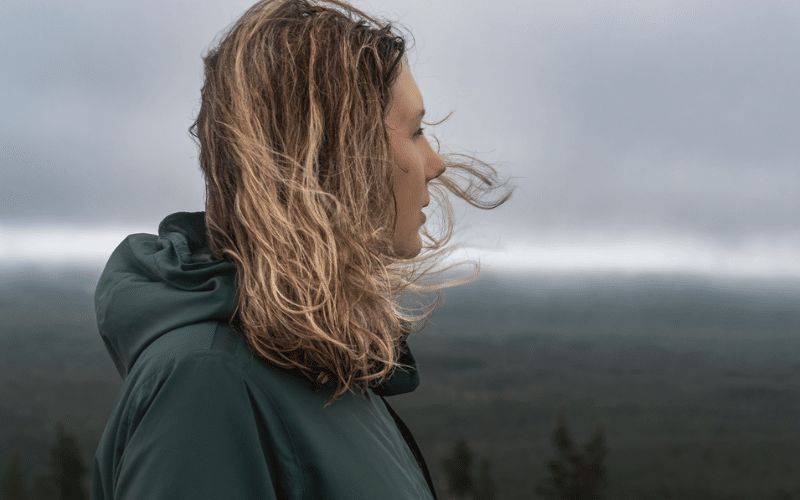 En kvinne ser utover et naturlandskap.