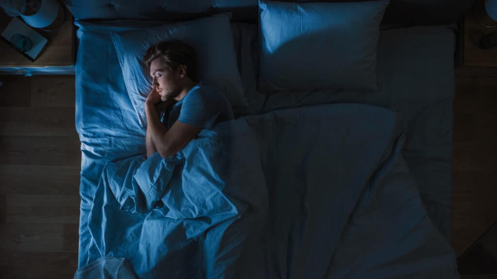 En ung mann ligger å sover